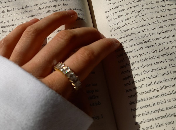 female-hand-on-an-open-book-reading-how-to-tell-stories